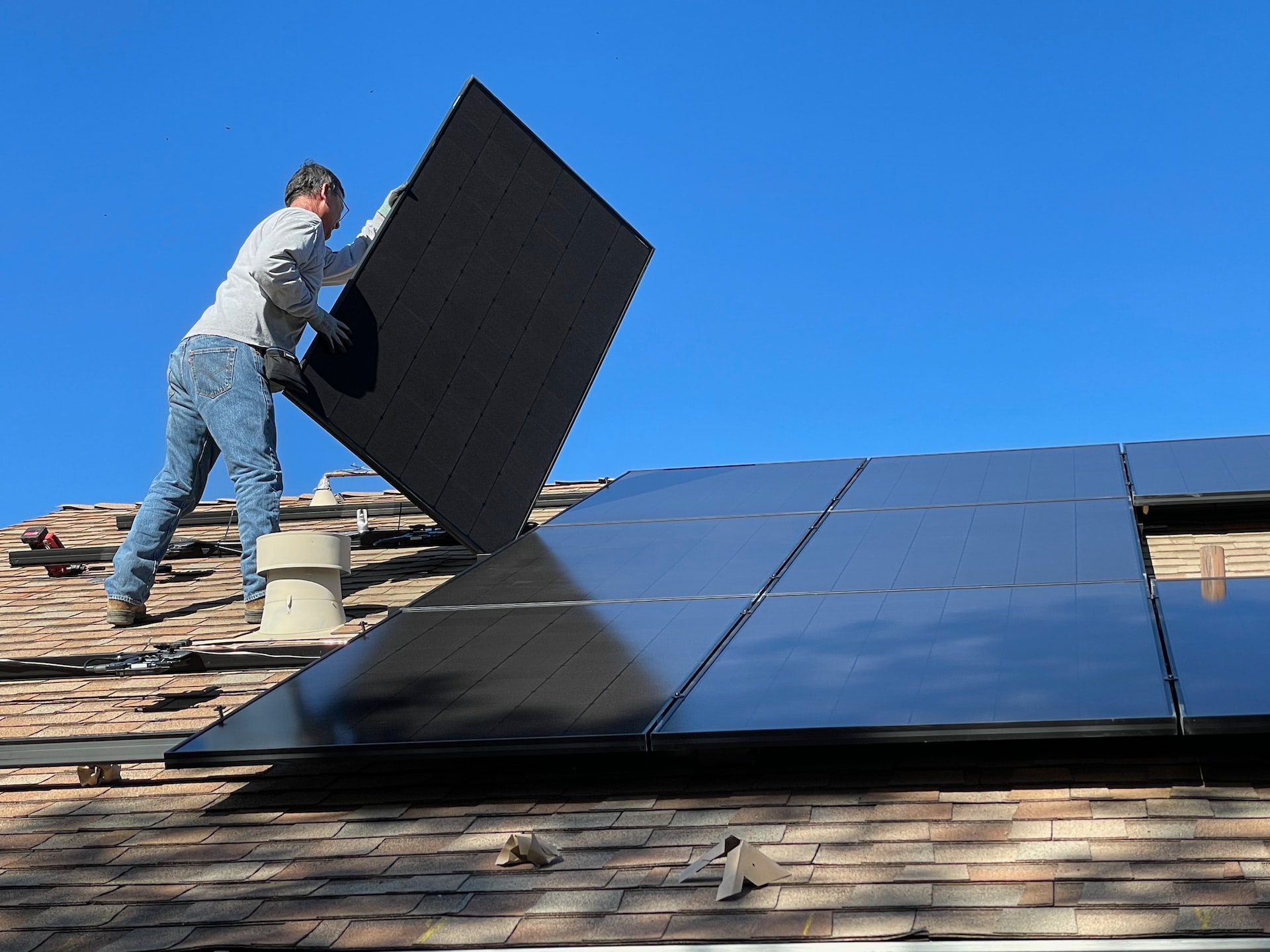 Solstice Solar installer on a residential rooftop installing solar PV panels in Texas,